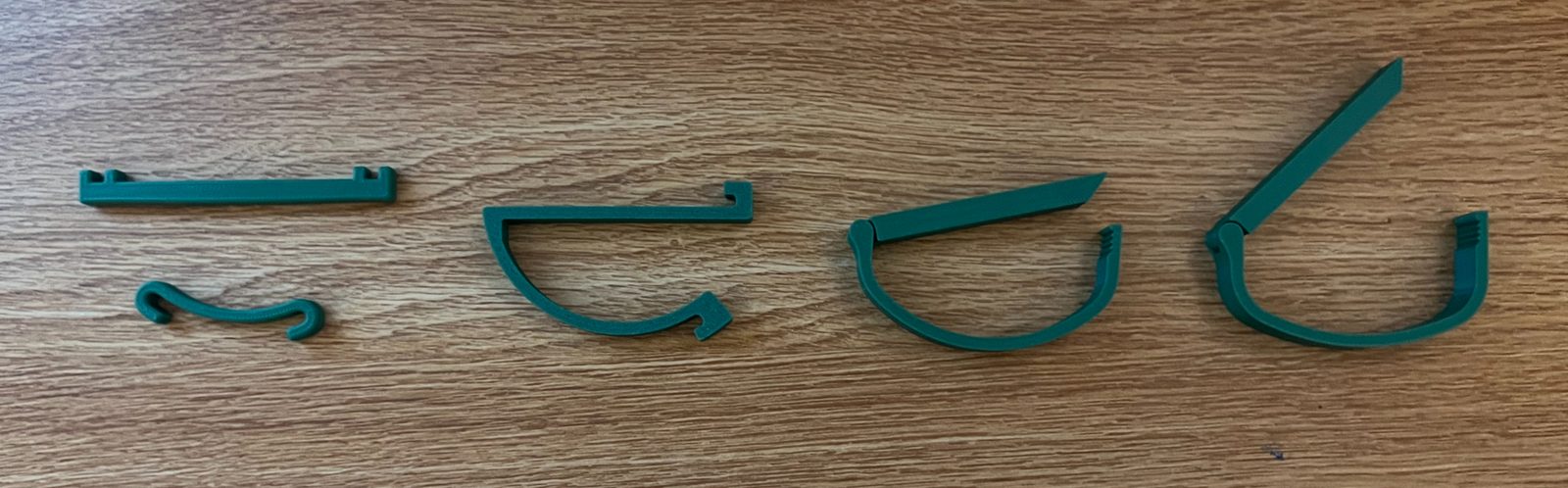 All capo prototypes lined up in order on a wooden table