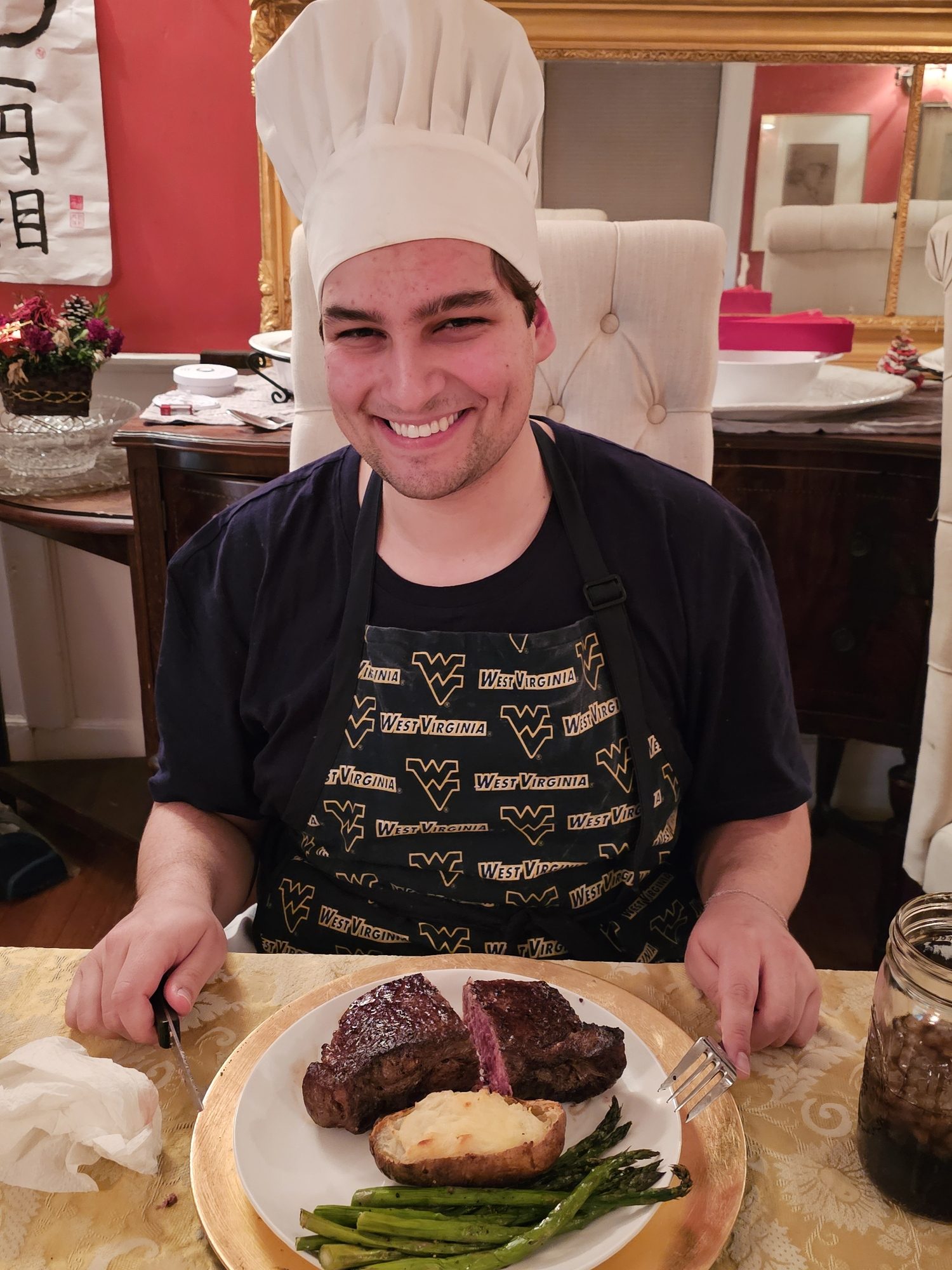 Robert in a chef's hat with a plated steak dinner